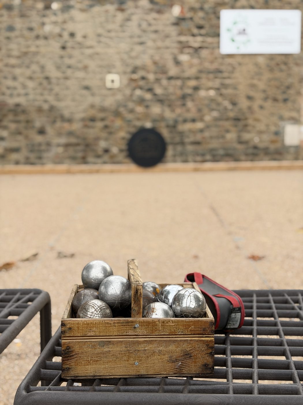 Une caisse de boules de pétanque au bord du terrain du Clos