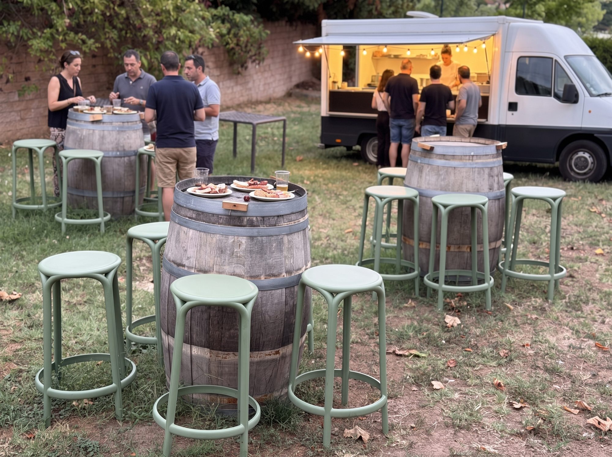 Un food truck installé dans le parc du Clos de l'Abbaye un mercredi soir, les convives debout autour des tonneaux