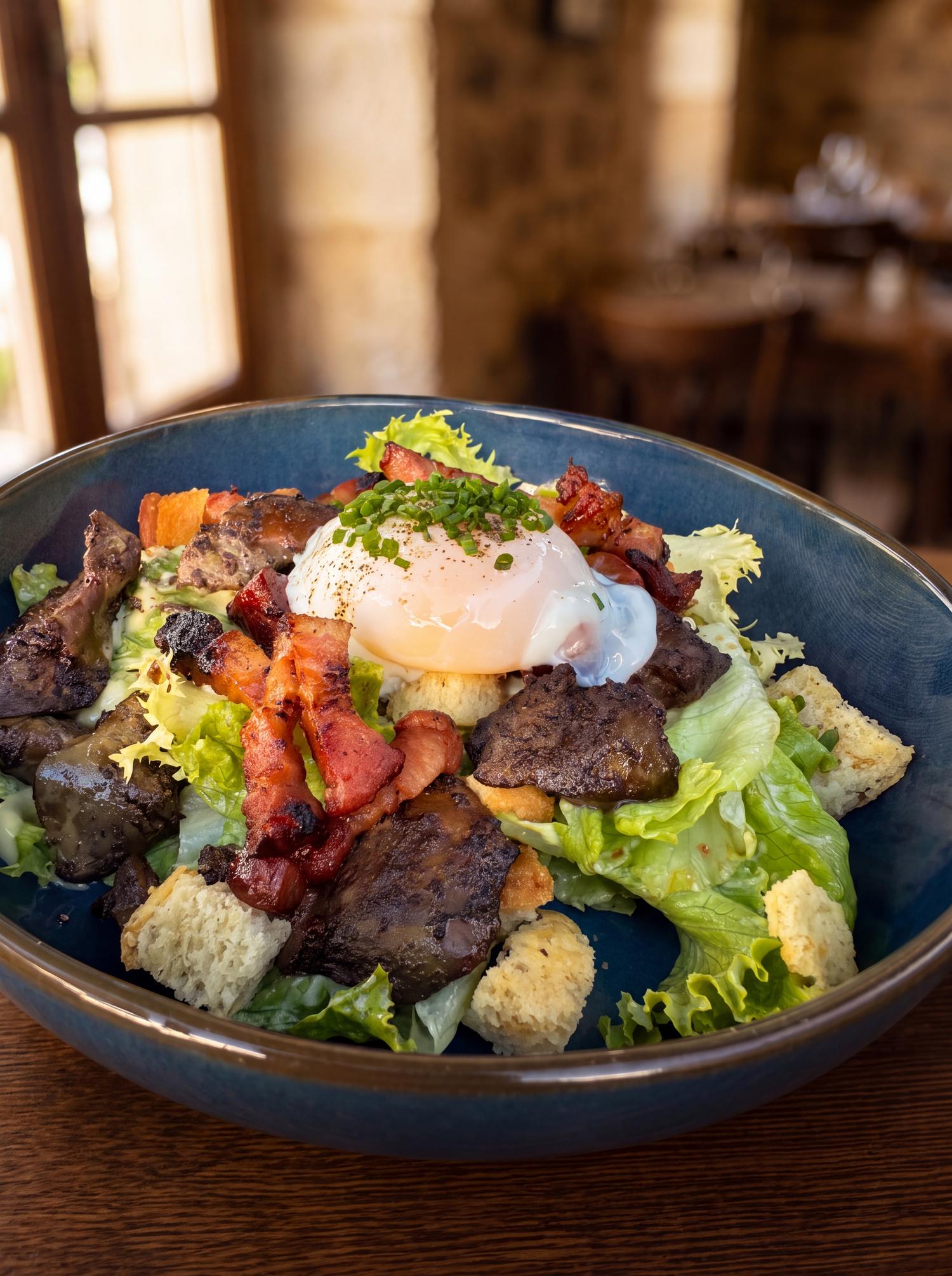 Salade lyonnaise, œuf poché, lardons et croûtons