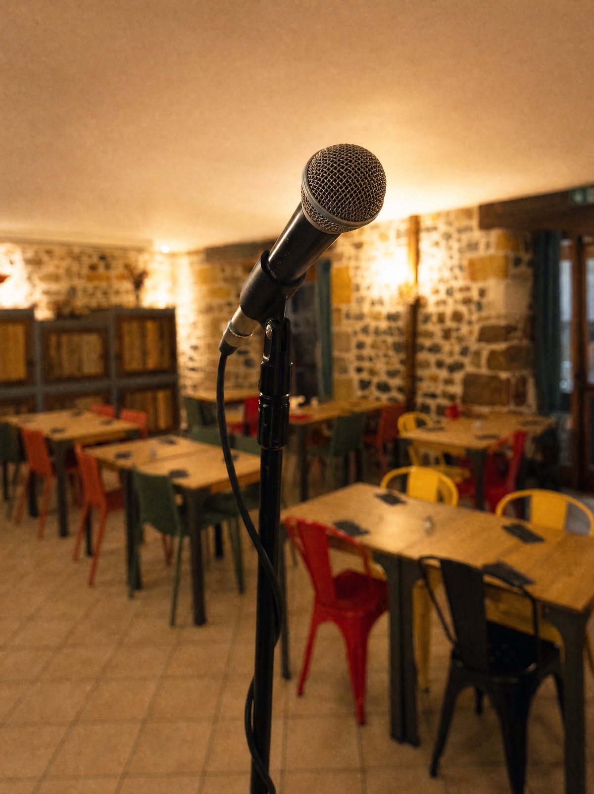 Un micro sur pied dans la grande salle du Clos de l'Abbaye, prêt pour la soirée karaoké